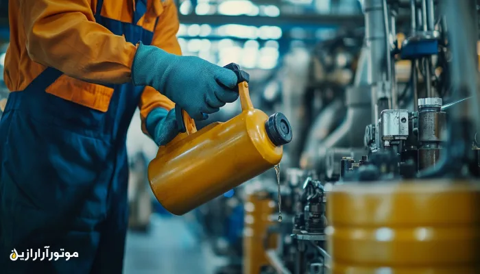 تکنسین صنعتی در حال روغن‌کاری دقیق تجهیزات با استفاده از ظرف فلزی مخصوص روانکار؛ نمونه‌ای از اجرای صحیح عملیات نگهداری پیشگیرانه در کارخانه
