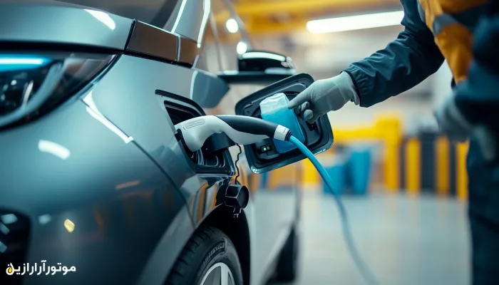 نمای نزدیک از تکنسینی که در حال اتصال کابل شارژ به یک خودروی برقی در فضای مدرن تعمیرگاه یا ایستگاه شارژ است، نماد حمل‌ونقل آینده و روانکارهای سازگار با خودروهای EV.