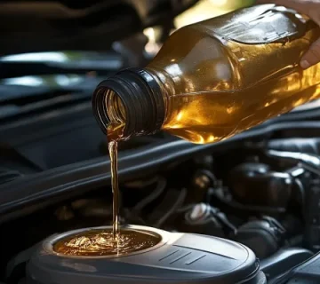 ریختن روغن موتور طلایی‌رنگ در موتور خودرو با درب باز