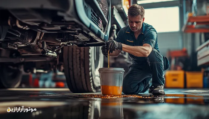 تکنسین سرویس ناوگان در حال تعویض روغن موتور دیزلی یک کامیون