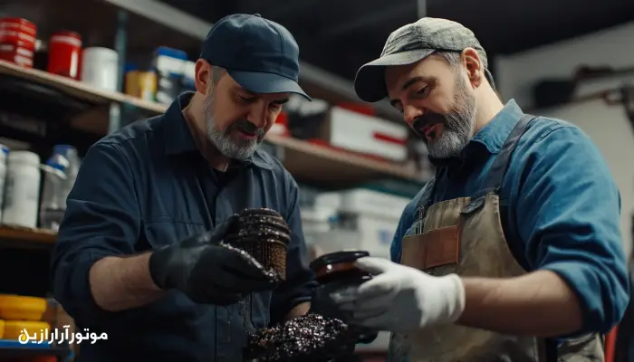 بررسی فیلتر روغن آسیبدیده توسط دو مکانیک در تعمیرگاه