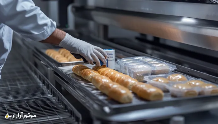 نمای بسته از اپراتور صنعتی در حال استفاده از روانکار بهداشتی با تأییدیه NSF در خط تولید نان بستهبندیشده – محیط استریل و کاملاً بهداشتی در کارخانه صنایع غذایی