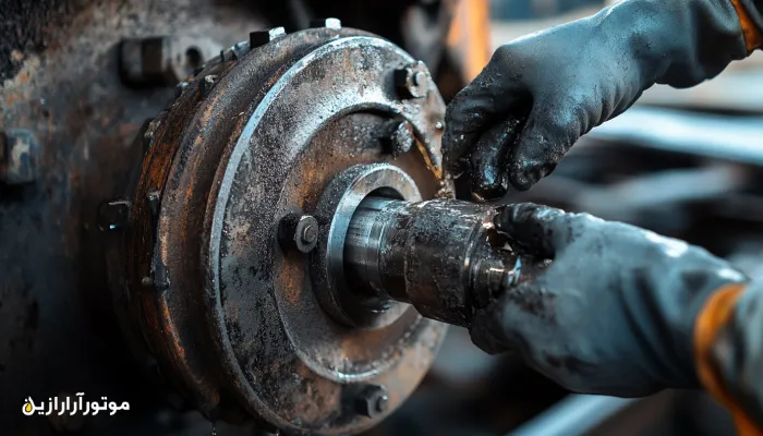 روانکاری یاتاقان محور لوکوموتیو با گریس صنعتی مقاوم به فشار – نمای نزدیک از عملکرد تکنسین با دستکش ایمنی در محیط تعمیرگاه ریلی