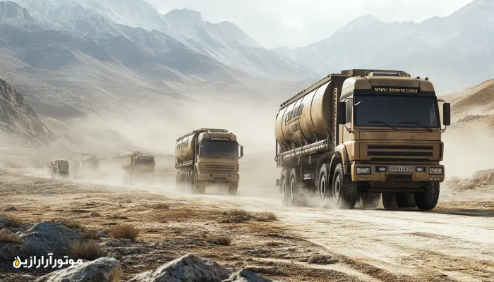 کاروانی از کامیون‌های صادراتی سنگین در حال عبور از جاده‌های کوهستانی و بیابانی تحت شرایط آب‌وهوایی سخت