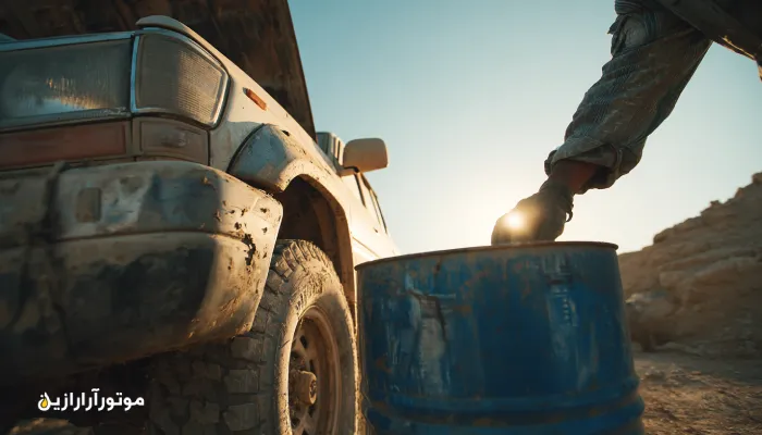 وانت در مسیر گردشگری قنات‌های فردوس، بررسی سطح روغن موتور در کنار بشکه آبی موتورازین، نور گرم کویری و زمینه مینیمال.. روغن موتور فردوس