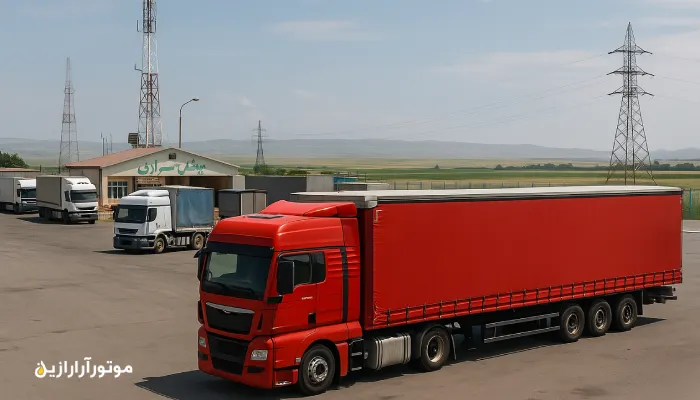 کامیون قرمز در پایانه مرزی بیلهسوار با چشمانداز دشت و برجهای برق